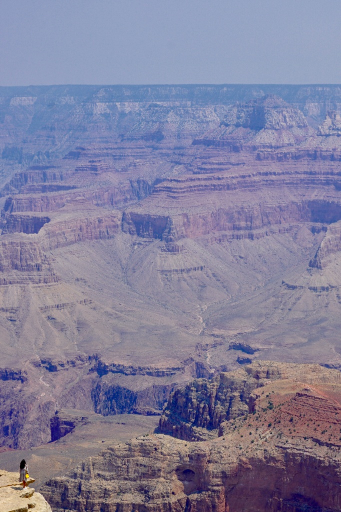 Depicts how small a person is in comparison to the Grand Canyon.